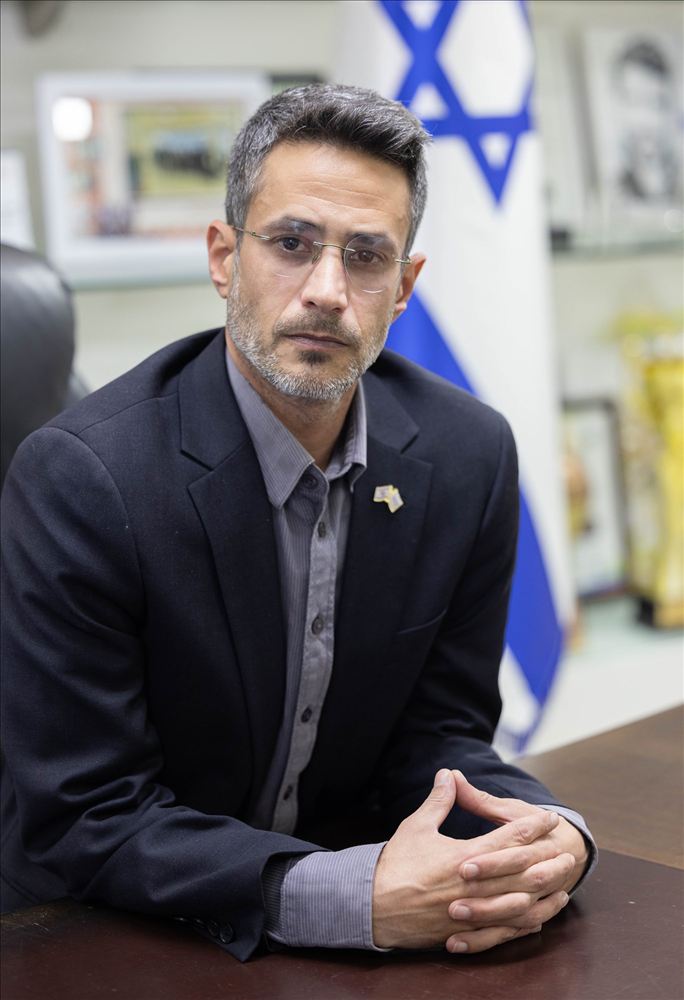 פורטרט של גבר במשרד ליד דגל ישראל