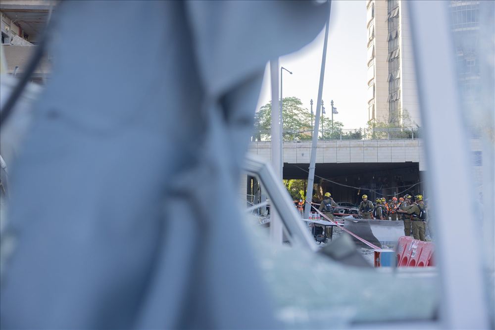 מבט מבעד לזכוכית שבורה אל כוחות הצלה במבנה פגוע